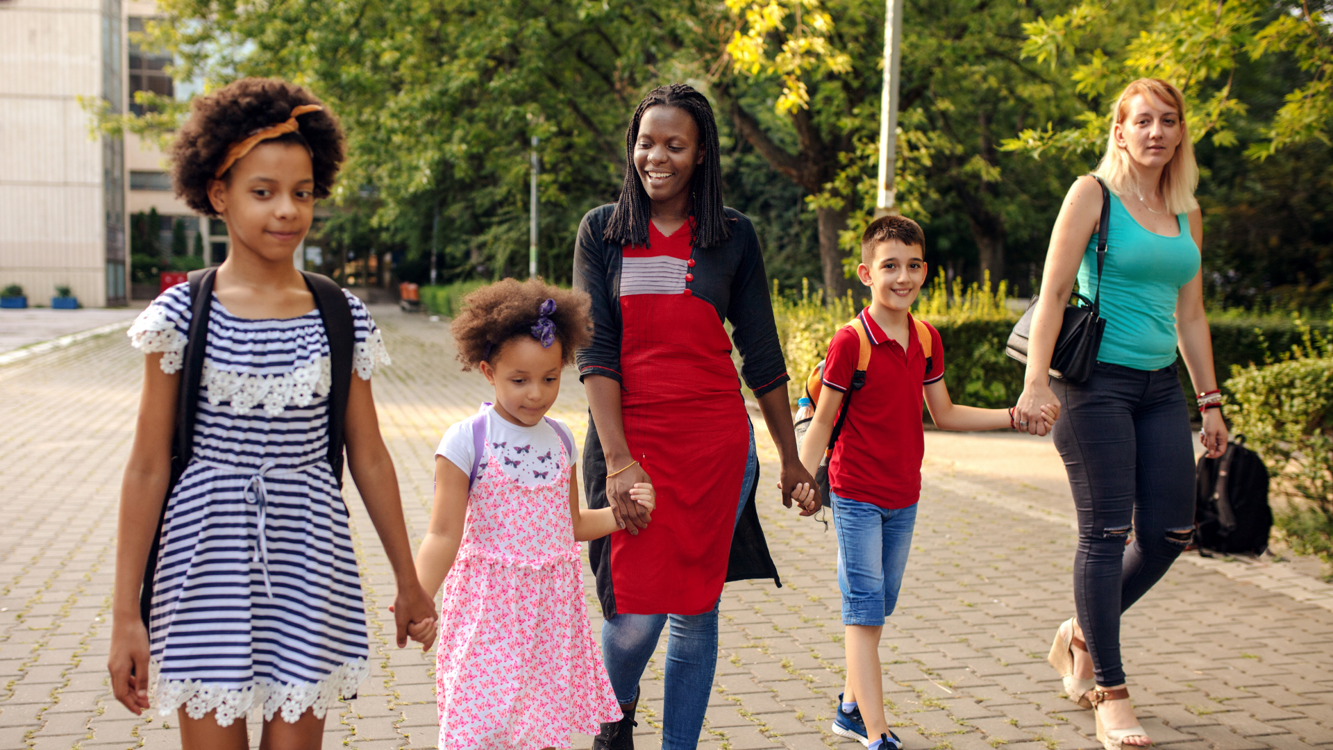 Two families holding hands and walking outside